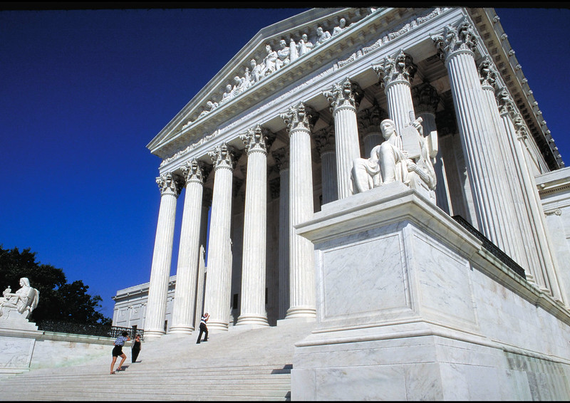 Image of the Supreme Court building in Washington, DC with people walking up the stairs.