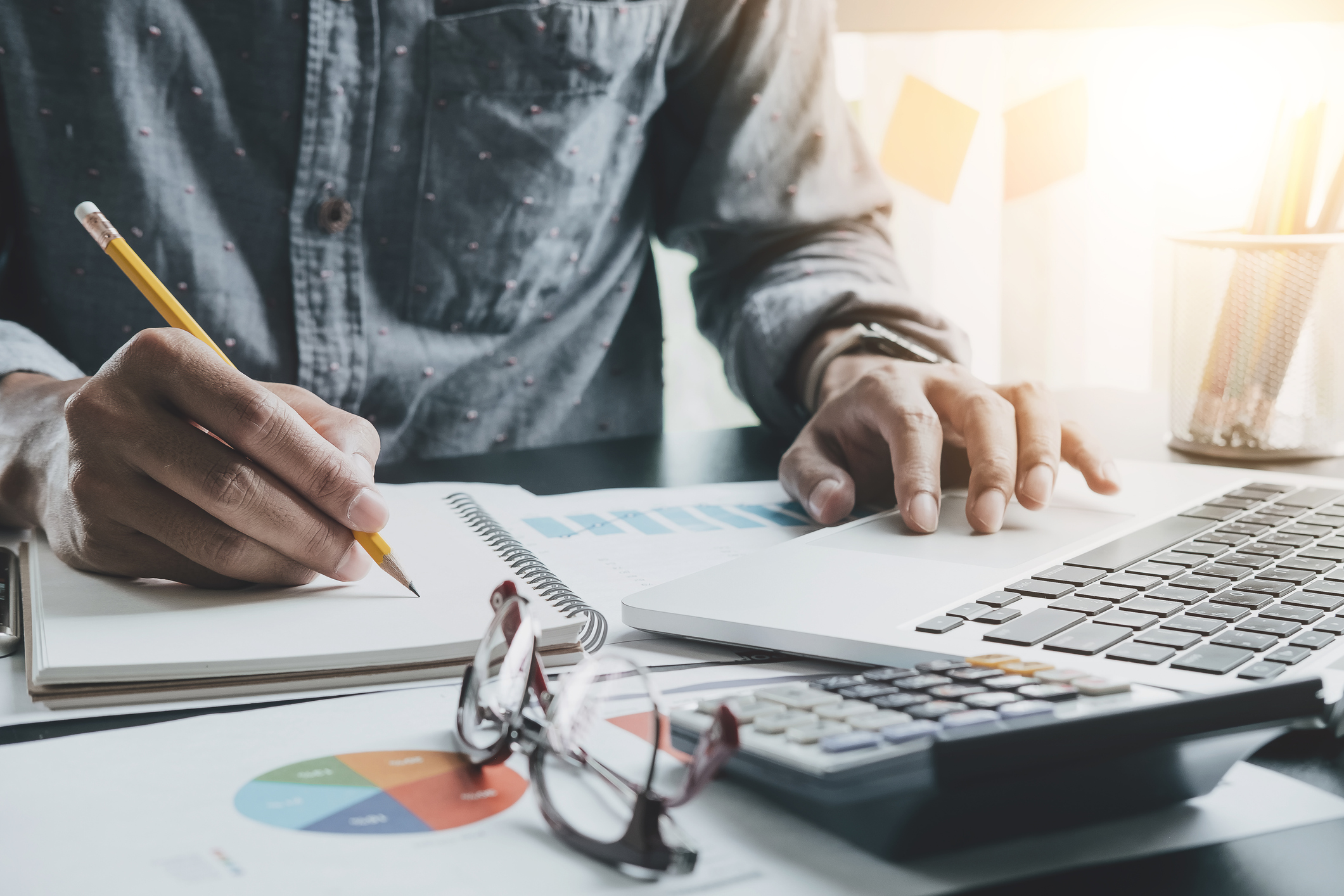 Image of a man at a desk taking notes and making calculations